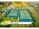 Aerial view of well-maintained community tennis courts surrounded by lush landscaping at 1466 Moon Valley Dr, Champions Gate, FL 33896