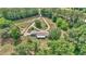 Aerial view of the property, showcasing its long driveway, lush greenery, and private setting at 2299 Nw 135Th Ln, Citra, FL 32113