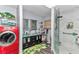 Full bathroom with a double vanity, stylish vessel sinks, glass shower, and a red washer/dryer combo at 2299 Nw 135Th Ln, Citra, FL 32113