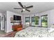 Cozy bedroom with a large window, a ceiling fan, a dresser with a TV on top, and a unique bed covering at 2299 Nw 135Th Ln, Citra, FL 32113