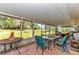 Screened in patio features brick floors and outdoor furniture and views of the spacious yard beyond at 2299 Nw 135Th Ln, Citra, FL 32113