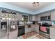 Modern kitchen features stainless steel appliances, gray cabinets, and a bright window over the sink at 2299 Nw 135Th Ln, Citra, FL 32113