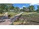 Scenic view of a home with a long driveway and fenced yard, set amidst mature trees at 2299 Nw 135Th Ln, Citra, FL 32113