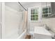 Bathroom featuring white tile, a shower-tub combination, and a window providing natural light at 2312 Corrine Dr, Orlando, FL 32803