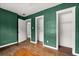 Bedroom showcasing green walls, hardwood floors, and closet space, providing a comfortable retreat at 2312 Corrine Dr, Orlando, FL 32803