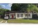 Charming single-story home featuring a red front door and a driveway with a parked car at 2312 Corrine Dr, Orlando, FL 32803