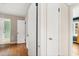 Hallway with neutral paint, hardwood floors, and multiple closets leading to different rooms at 2312 Corrine Dr, Orlando, FL 32803
