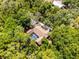 Aerial view of a single-Gathering home featuring a screened-in pool surrounded by dense trees for optimal privacy at 2705 Curryville Rd, Chuluota, FL 32766