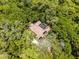 Overhead shot of a private home boasting a screened-in pool area, nestled among a thick, vibrant forest setting at 2705 Curryville Rd, Chuluota, FL 32766
