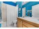 Well-lit bathroom featuring a tub, tile flooring, and bright blue walls accented with floral wallpaper at 2705 Curryville Rd, Chuluota, FL 32766