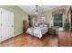 Spacious bedroom with hardwood floors, windows, and an open doorway to the bathroom at 2705 Curryville Rd, Chuluota, FL 32766