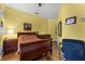 Cozy bedroom with hardwood floors, wood furniture and bright yellow walls at 2705 Curryville Rd, Chuluota, FL 32766