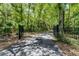 Long paved driveway leading through a wooded area, secured by a black iron gate at 2705 Curryville Rd, Chuluota, FL 32766