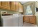 Functional laundry room with wooden cabinets, sink, and washer/dryer for convenience at 2705 Curryville Rd, Chuluota, FL 32766