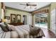 Cozy main bedroom with a ceiling fan and sliding glass doors leading to the screened-in pool area at 2705 Curryville Rd, Chuluota, FL 32766