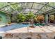 Enclosed pool featuring tropical landscaping, a small waterfall feature, and stone surroundings at 2705 Curryville Rd, Chuluota, FL 32766