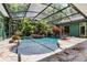 Enclosed pool area featuring tropical landscaping, a waterfall feature, and stone surroundings at 2705 Curryville Rd, Chuluota, FL 32766