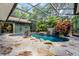 Enclosed pool with a rock waterfall and lush landscaping at 2705 Curryville Rd, Chuluota, FL 32766