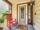 Close-up of the front entrance featuring a rocking chair, decorative wreath, and stylish exterior lighting at 2706 Donaldson Dr, Orlando, FL 32812