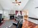 Open-concept living room with a fireplace, wood floors, vaulted ceiling, and views of the dining room at 2706 Donaldson Dr, Orlando, FL 32812