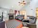 Open-concept living room with a fireplace, wood floors, vaulted ceiling, and views of the dining room and kitchen at 2706 Donaldson Dr, Orlando, FL 32812