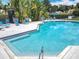 Beautiful community pool with lounge chairs, steps, and lush tropical landscaping at 2706 Donaldson Dr, Orlando, FL 32812