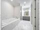 Modern bathroom with marble floors, soaking tub, and separate vanity area with stylish cabinetry at 278 Acorn Dr, Longwood, FL 32750