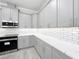 Modern kitchen featuring gray cabinets, stainless steel appliances, and white marble countertops at 278 Acorn Dr, Longwood, FL 32750