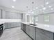 Open concept kitchen with gray cabinets, stainless steel appliances, and large island with marble countertop at 278 Acorn Dr, Longwood, FL 32750