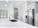 Modern kitchen island with sink and faucet, stainless steel refrigerator, and adjacent laundry room at 278 Acorn Dr, Longwood, FL 32750
