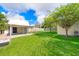 Expansive backyard with lush lawn, mature trees, and covered patio area at 2814 Conway Gardens Rd, Orlando, FL 32806