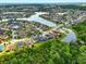 An aerial view highlights a picturesque neighborhood nestled around a lake with mature trees at 2926 Boating Blvd, Kissimmee, FL 34746