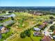 Aerial view of a golf course and pond surrounded by homes in the community at 2926 Boating Blvd, Kissimmee, FL 34746