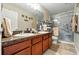 Bathroom with double sinks, granite counters, and a glass-enclosed shower at 2926 Boating Blvd, Kissimmee, FL 34746