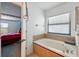 Bright bathroom with a large soaking tub and a view into the bedroom at 2926 Boating Blvd, Kissimmee, FL 34746