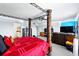 Spacious bedroom featuring a unique four-poster bed and a cozy seating area with a large-screen TV at 2926 Boating Blvd, Kissimmee, FL 34746