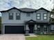 Charming two-story home with a black garage door, manicured lawn, and a welcoming front entrance at 2926 Boating Blvd, Kissimmee, FL 34746