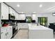Bright kitchen featuring white cabinets, an island, stainless steel appliances, and backyard views at 2926 Boating Blvd, Kissimmee, FL 34746
