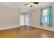 Comfortable room features wood flooring, a ceiling fan, window dressed with curtains, and sliding door access at 2975 White Cedar Cir, Kissimmee, FL 34741