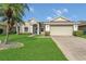 Charming single-story home showcasing a well-manicured lawn and attached two-car garage at 2975 White Cedar Cir, Kissimmee, FL 34741