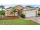 Inviting home exterior features a two-car garage, manicured lawn, and lovely landscaping at 311 Lakebreeze Cir, Lake Mary, FL 32746