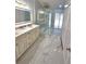Bright bathroom featuring an illuminated mirror, double vanity and glass shower with gold hardware at 3146 Byington Terrace Ter, Deltona, FL 32738