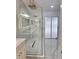 Modern bathroom featuring a glass shower with gold fixtures and white marble tile throughout at 3146 Byington Terrace Ter, Deltona, FL 32738