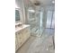 Bright bathroom featuring an illuminated mirror, vanity and glass shower with modern gold hardware at 3146 Byington Terrace Ter, Deltona, FL 32738
