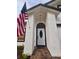 Close-up of a front door and textured siding with an American flag at 3146 Byington Terrace Ter, Deltona, FL 32738