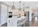 Beautiful kitchen boasts white cabinetry, stainless steel appliances, and an island with seating at 3361 Orange Rose Loop, Apopka, FL 32712