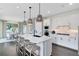 Bright, all-white kitchen featuring pendant lighting, modern appliances, and an island with barstool seating at 3361 Orange Rose Loop, Apopka, FL 32712