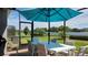 Outdoor dining on a screened lanai with views of lush landscaping and a lake at 3986 Bedford Ave, Winter Haven, FL 33884