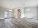 Expansive living room with modern gray floors, access to an outdoor patio, and stylish hanging chandeliers at 404 Wilshire Dr, Casselberry, FL 32707