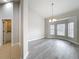Airy living room with gray floors, large windows, and a view to the laundry room at 404 Wilshire Dr, Casselberry, FL 32707